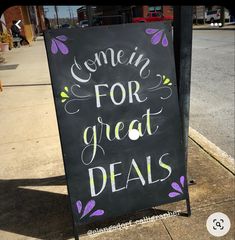 a sign that says come in for great deals on the sidewalk next to a street