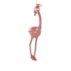 a pink flamingo christmas ornament hanging from a string on a white background