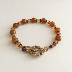 Nwot Handmade - Beautiful Glass And Crystal Bead Bracelet In Shades Of Warm Earth Colors - Yellow And Rust Reddish Brown With Black And Goldtone Metal Spacer Accents. The Bracelet Measures About 8", Including An Ornate Antiqued Goldtone Clasp. Adjustable Amber Beaded Bracelets With Faceted Beads, Amber Bracelets With Colorful Beads, Amber Beaded Stretch Bracelet With Round Beads, Amber Bracelets With Colorful Round Beads, Vintage Adjustable Beaded Bracelets With 8mm Beads, Adjustable Amber Beaded Crystal Bracelet, Brown Metal Beaded Bracelets, Adjustable Beaded Amber Stretch Bracelet, Adjustable Brown Bracelet With Gold Beads