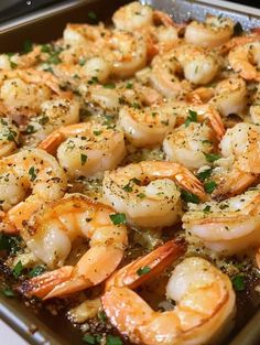 a pan filled with cooked shrimp and garnished with parsley sprinkled on top