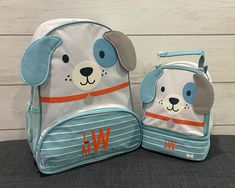 two children's backpacks, one with a dog face and the other with a name on it