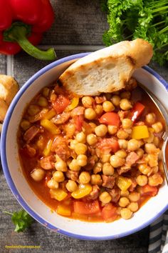 a bowl of spanish chorizo and chickpea stew with bread on the side