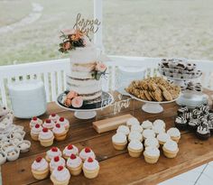 a table topped with lots of cupcakes and cakes