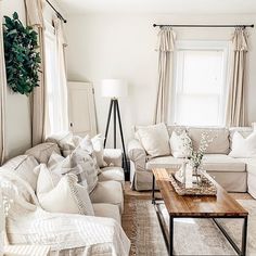 a living room filled with white furniture and pillows