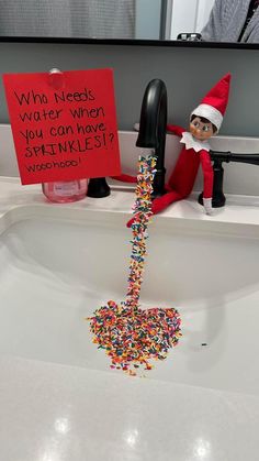 an elf is sitting in the sink with sprinkles