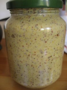 a jar filled with yellow liquid sitting on top of a wooden table