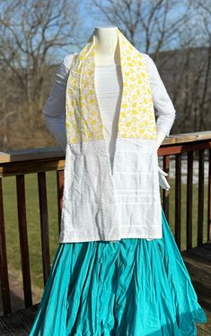 a woman's white shirt and blue skirt on a wooden rail