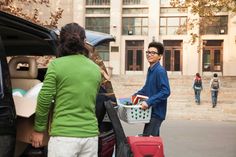 two people loading luggage into the back of a car