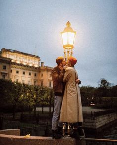 two people standing next to each other under a street light