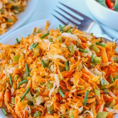 a white plate topped with shredded carrots and green onions