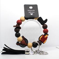 a bracelet made out of wooden beads and other items on a white table with a black keychain