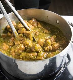 a pan filled with meat and vegetables on top of a stove