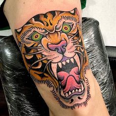 a close up of a person's leg with a tiger tattoo on it,