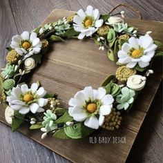 a wreath made out of felt and flowers on a wooden board with the words old bird design