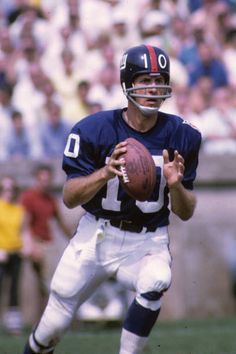 a man holding a football on top of a field