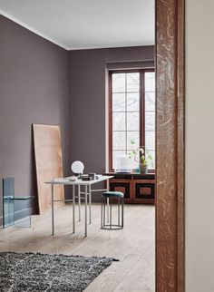 a dining room with purple walls and wooden floors