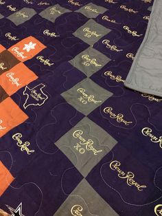 a quilted bed spread with gold writing on purple and orange squares that spell out the word god