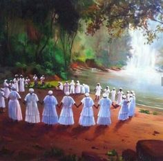 a group of people standing in front of a waterfall wearing white dresses and holding hands