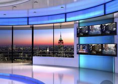 an empty room with multiple televisions on the wall and cityscape in the background