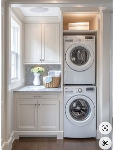 a washer and dryer in a white laundry room next to cabinets with drawers