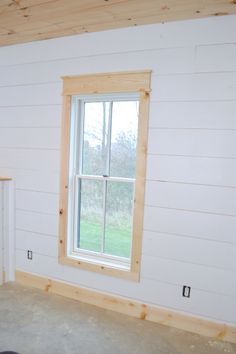 an empty room with white walls and wood trim