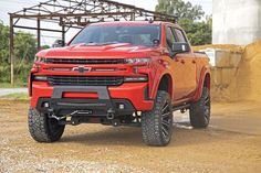 a red truck is parked in the dirt