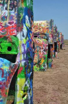 there are many cars covered in graffiti on the beach