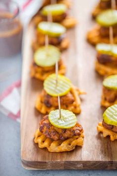 small appetizers with pickles and cheese are on a wooden platter, ready to be eaten