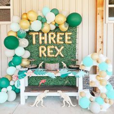 there is a table with balloons and some decorations on it that says three r ex