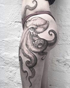 an octopus tattoo on the back of a woman's thigh