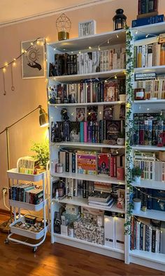 a bookshelf filled with lots of books next to a stair case in a living room