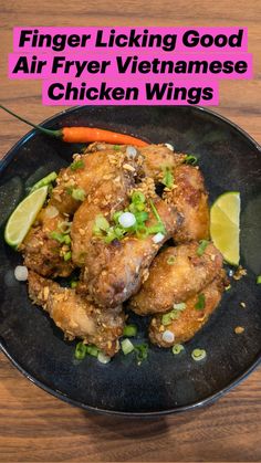 a black plate topped with fried chicken wings