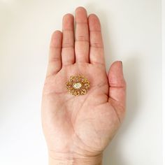 The listing is for a Vintage Seed Pearl Brooch. The brooch features a prong set mother of pearl flat cabochon with beautiful open work swirling gold frame. The decoratively engraved gold frame is accented with 8 small seed pearls set around the center mother of pearl flat cabochon. Measurement: 0.879 inches long x 0.982 inches wide. Weight: 3.4 grams Markings: unmarked but tests as 10K. Condition: Excellent condition. Has a working C-clasp closure. ❤All items in my shop are Estate, Vintage, and Luxury Gold Brooches With Cabochon, Antique Gold Brooch With Gemstone, Antique Gold Gemstone Brooch, Vintage Gold Brooches With Rose Cut Diamonds, Elegant Gold Filigree Brooches, Elegant Yellow Gold Enamel Pin Gift, Luxury Gold Brooches With Rose Cut Diamonds, Gold Brooches With Intricate Design For Wedding, Luxury Gold Brooches With Intricate Design