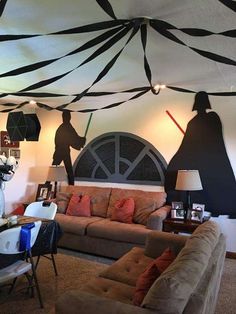 a living room filled with lots of furniture under a black and white striped ceiling covering