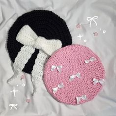 two crocheted hats laying next to each other on top of a white sheet