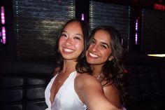 two young women taking a selfie in a club or bar with their arms around each other