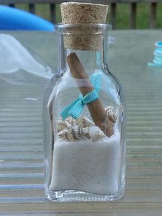 a glass bottle filled with sand and sea shells