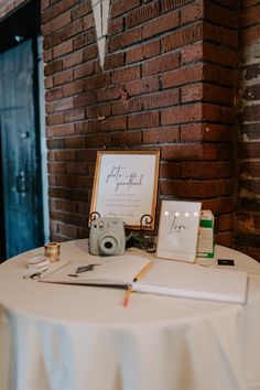 the table is set up for an event with two pictures and a pen on it