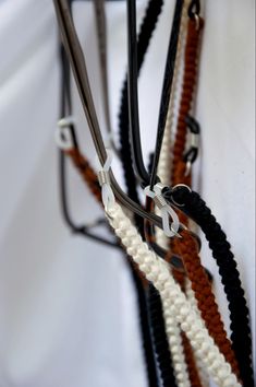 a group of different colored ropes attached to each other on a white background with black, brown, and white cords