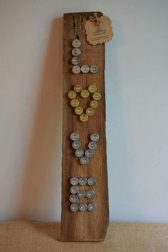 a wooden board with buttons on it and a tag hanging from the top that says love