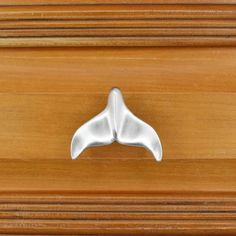 a close up of a drawer handle on a wooden cabinet with wood grained surface