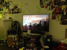 a flat screen tv sitting on top of a wooden table next to a pile of boxes