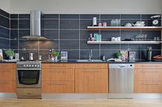 a modern kitchen with stainless steel appliances and wood cabinets is pictured in this image from the front view