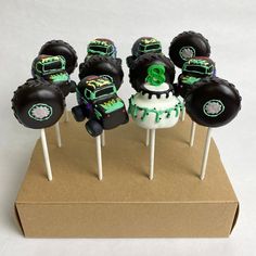 cake pops with monster trucks on them sitting on top of a cardboard box