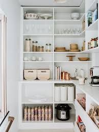 an organized pantry with lots of white shelves