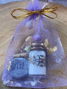 a blue glass jar with gold and purple decorations on it sitting in a clear bag