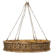 a hanging planter made out of wood and metal with ornate carvings on the rim