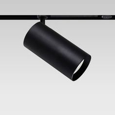 a black lamp hanging from a metal bar on a gray background with the light turned off