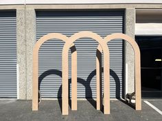 three wooden arches sitting in front of a garage door