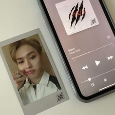 a cell phone sitting next to an image of a person on the screen and another photo